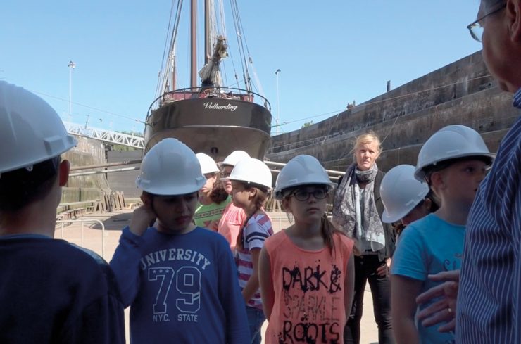 Kinderen luisteren aandachtig naar uitleg over het droogdok in Hellevoetsluis