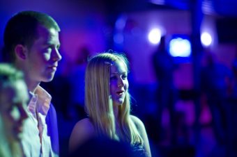 Twee jongeren in blauw licht kijken naar podium