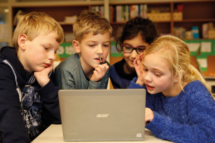 Vier leerlingen samen achter een laptop