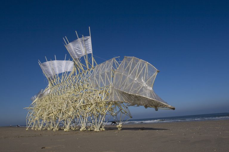 Groot wezen gemaakt van pvc-pijp, tie-wraps en plastic beweegt over het strand, gemaakt door kunstenaar Theo Jansen