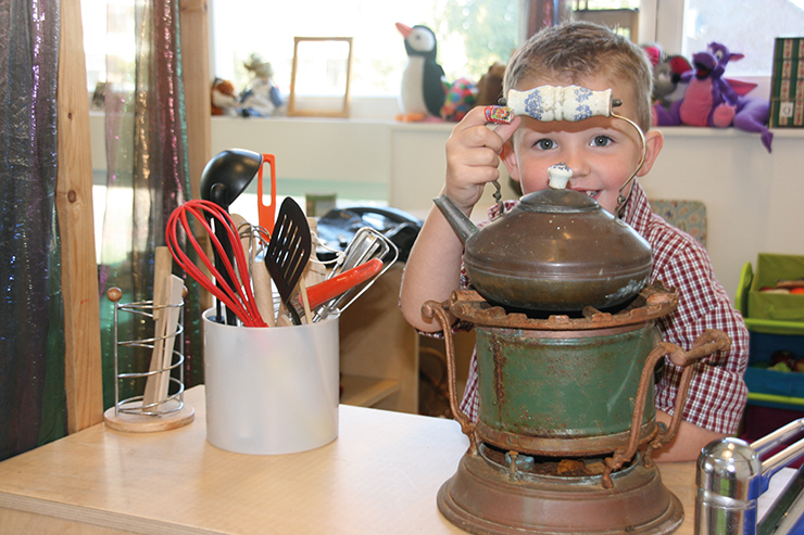 Jongetje voelt aan handvat historische theepot