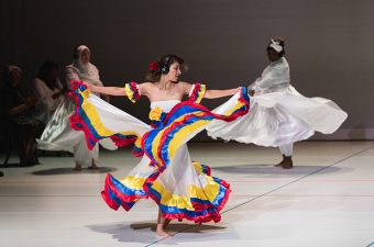 Vrouwen in wervelende jurken dansen op een podium tijdens optreden van Women Connected - Foto: Hanna Rosalie
