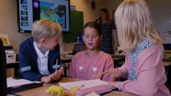 Drie kinderen met elkaar in gesprek tijdens creatieve les