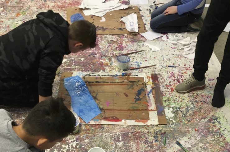 Kinderen zitten op de grond en schilderen tijdens cultuureducatie in de Hoeksche Waard