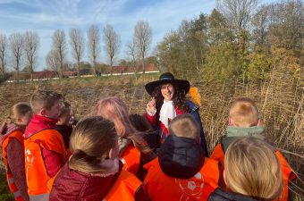 Leerlingen luisteren aandachtig naar de gids bij de Oude Hollandse Waterlinie