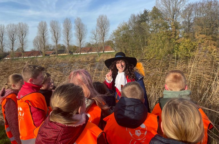 Leerlingen luisteren aandachtig naar de gids bij de Oude Hollandse Waterlinie