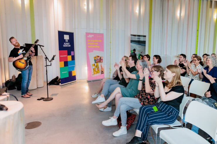 Deelnemers aan de training Cultuurcoordinator klappen voor muzikant