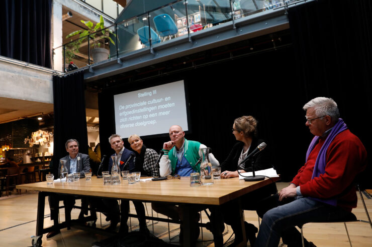 Panelgesprek tijdens Zuid-Hollands Cultuurdebat. Verschillende politieke partijen zitten aan tafel en zijn met elkaar in gesprek.