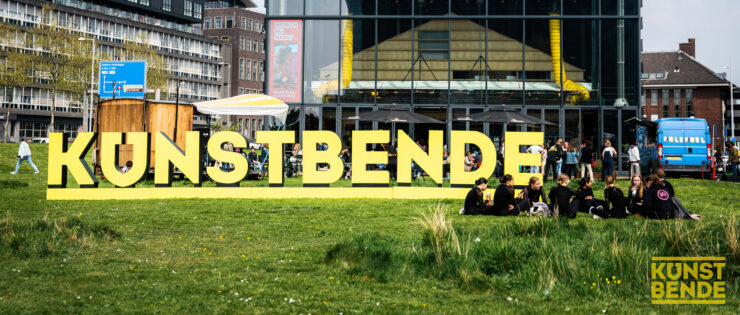 Kunstbende in grote 3D-letters op grasveld.