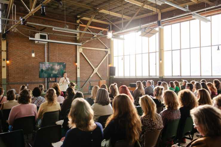 spreker en luisterend publiek in de zaal