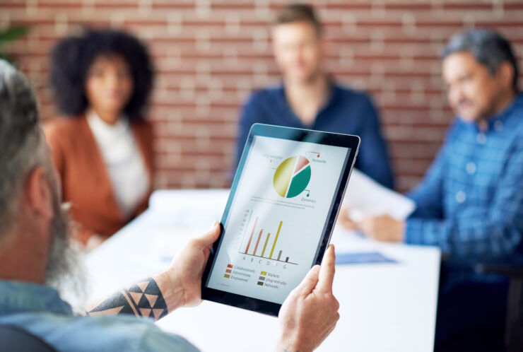 Man met tablet in zijn hand waarop diagrammen te zien zijn.