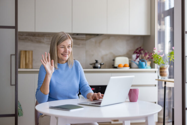 Senior woman actively engaging in a video call with a laptop.